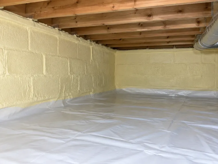 Crawl space foundation walls coated with closed-cell spray foam
