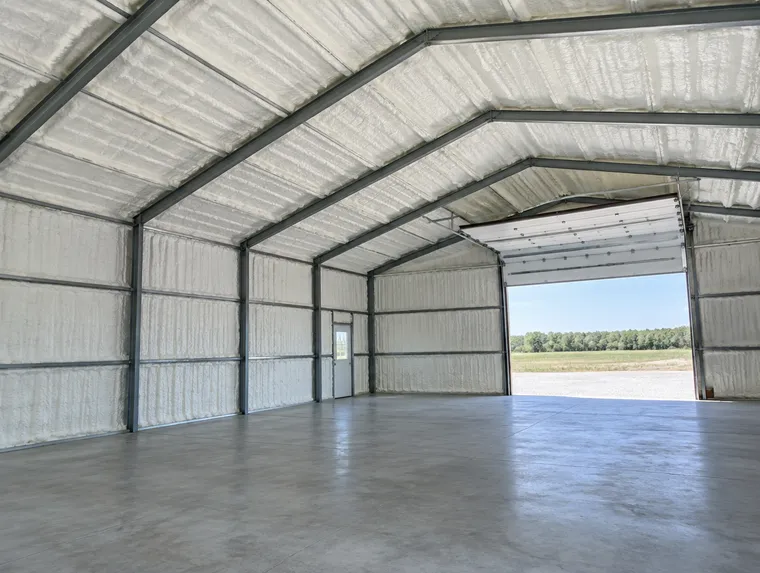Metal pole barn roof and walls covered in closed-cell spray foam